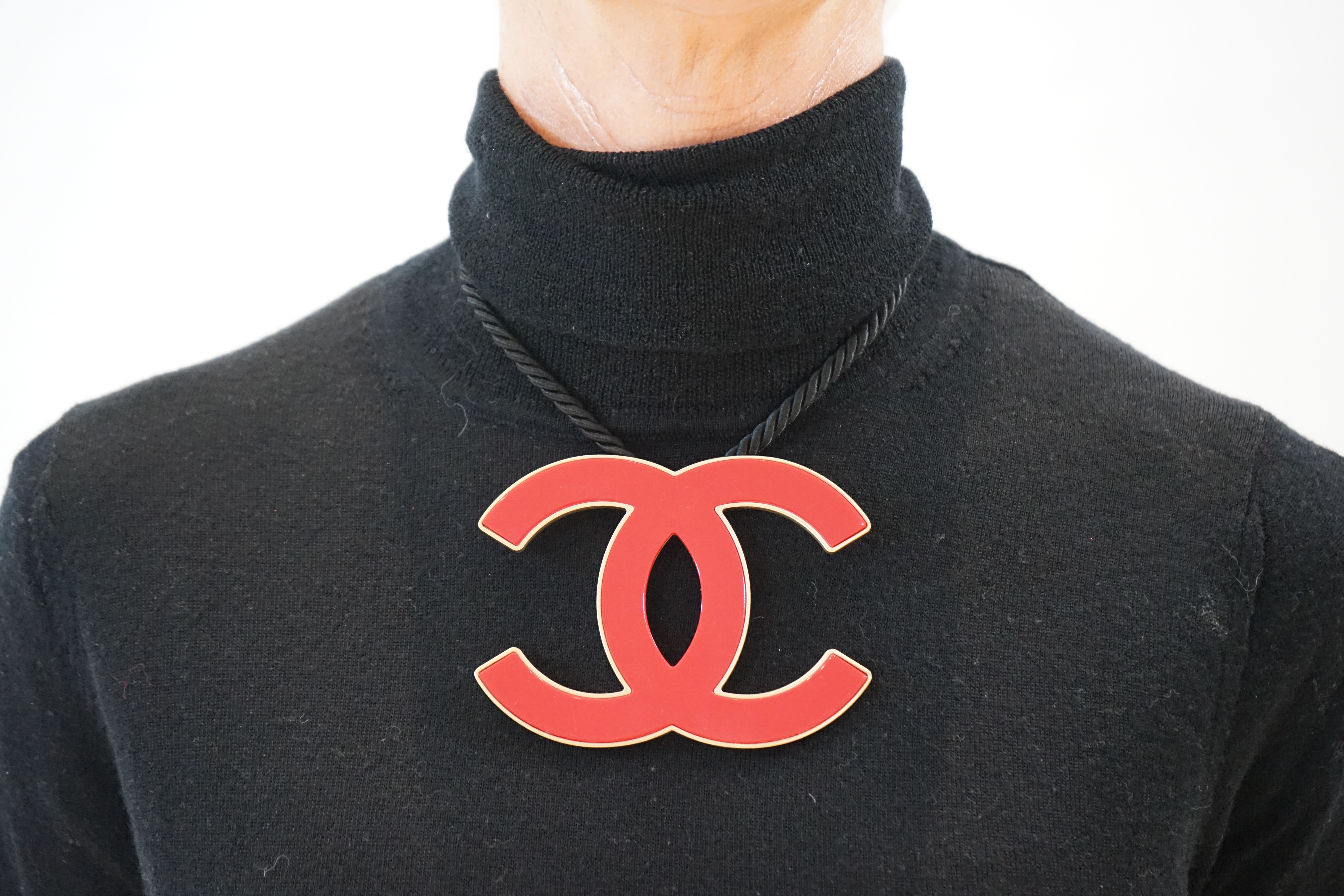 A Chanel CC red metal enamel and gold hardware fabric large choker evening necklace, cord length 39.5cm, charm width 10.75cm, height 8.25cm